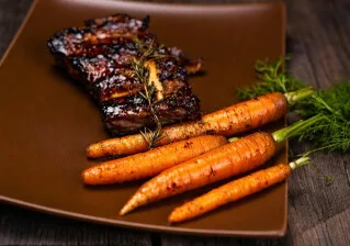 Oven-roasted pork ribs with citrus-glazed carrots